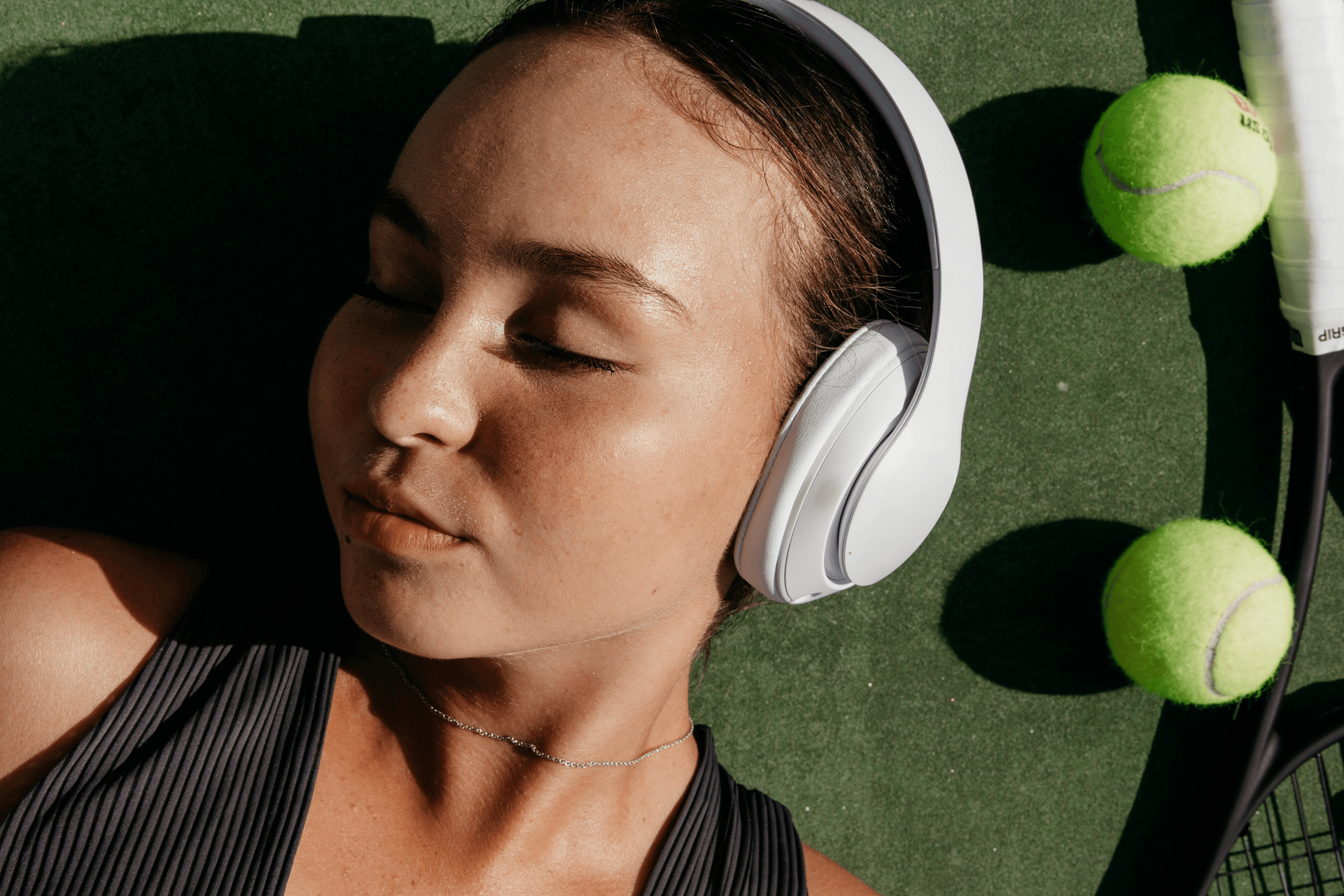 Woman with headphones on tennis court